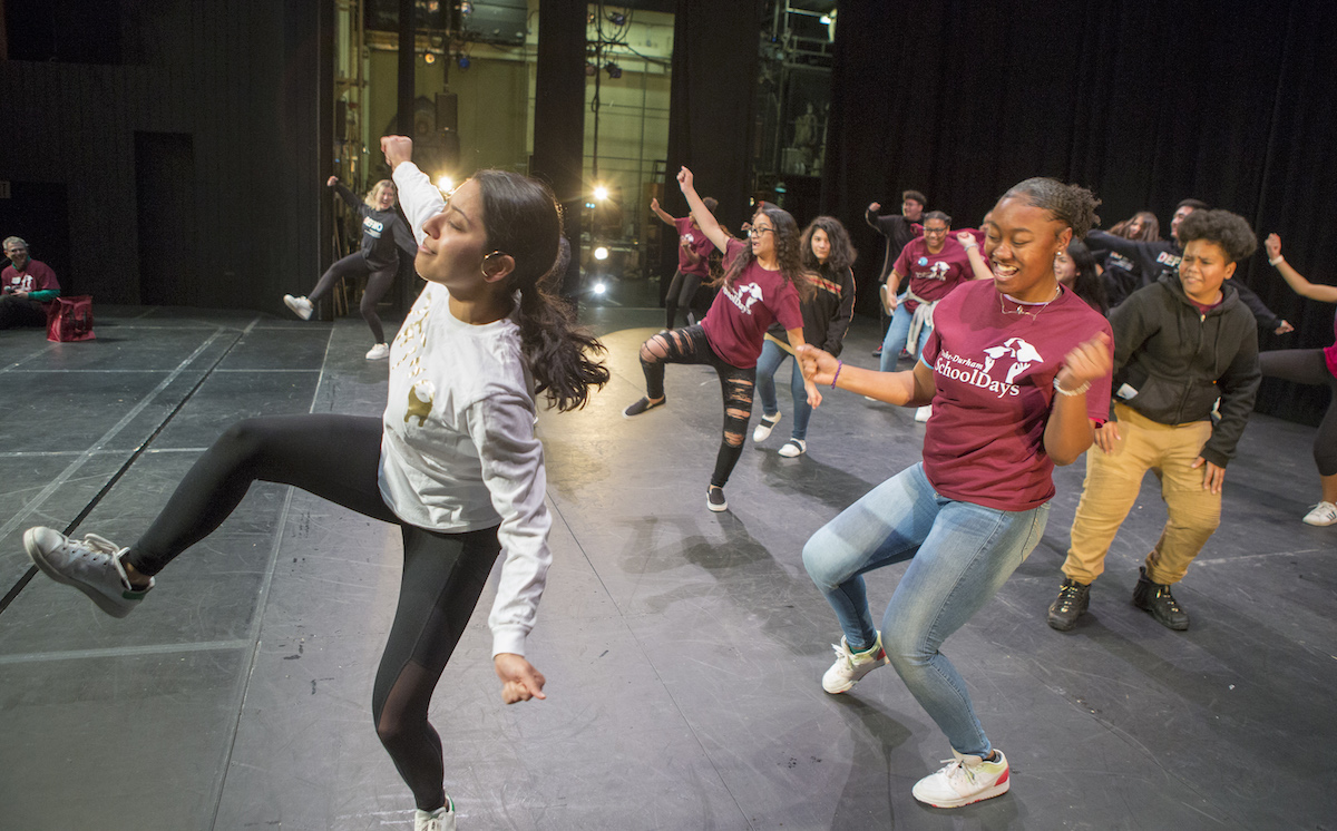 Students from DefMo, Duke's premier multicultural dance group, teach dance moves to eighth graders