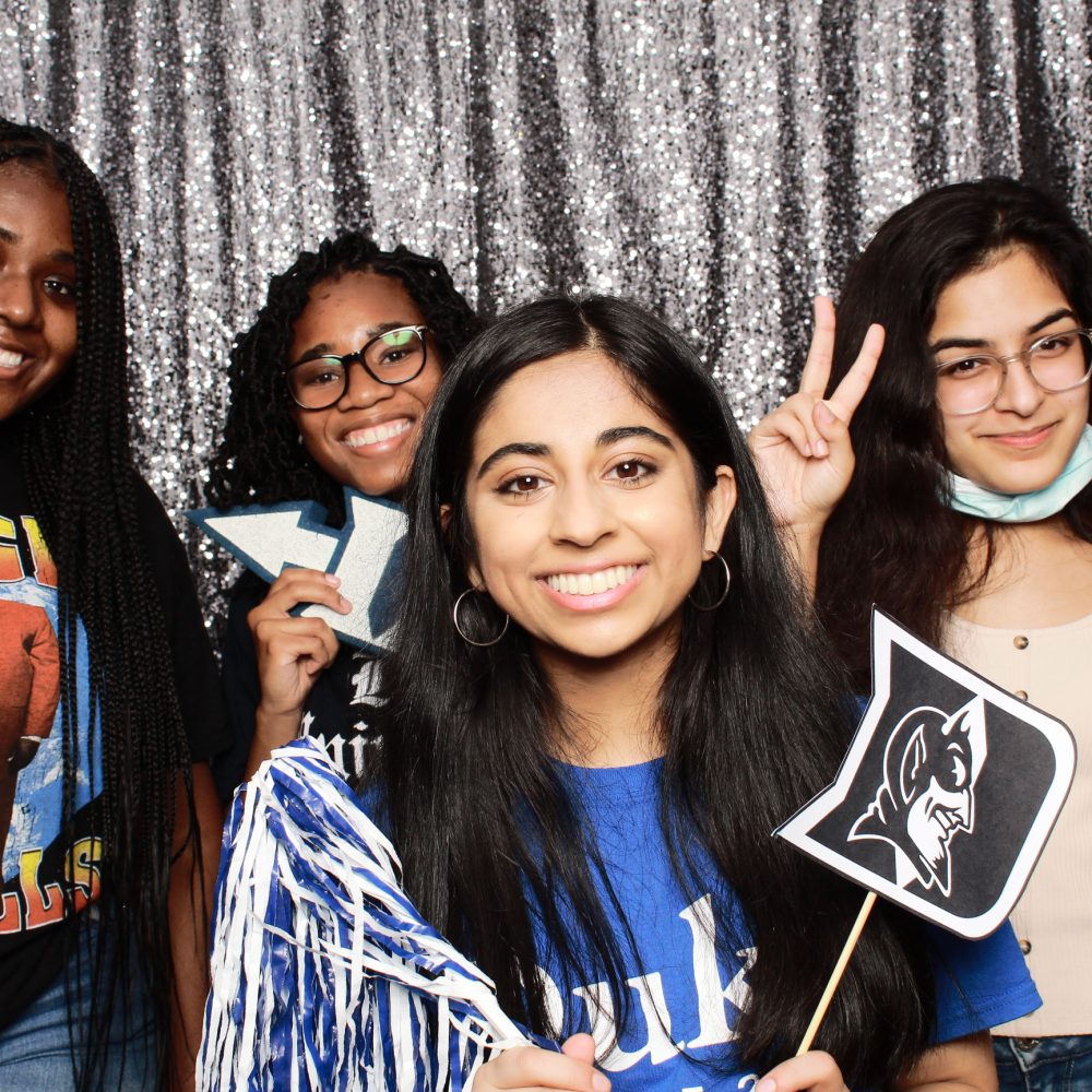 four students pose in photo booth