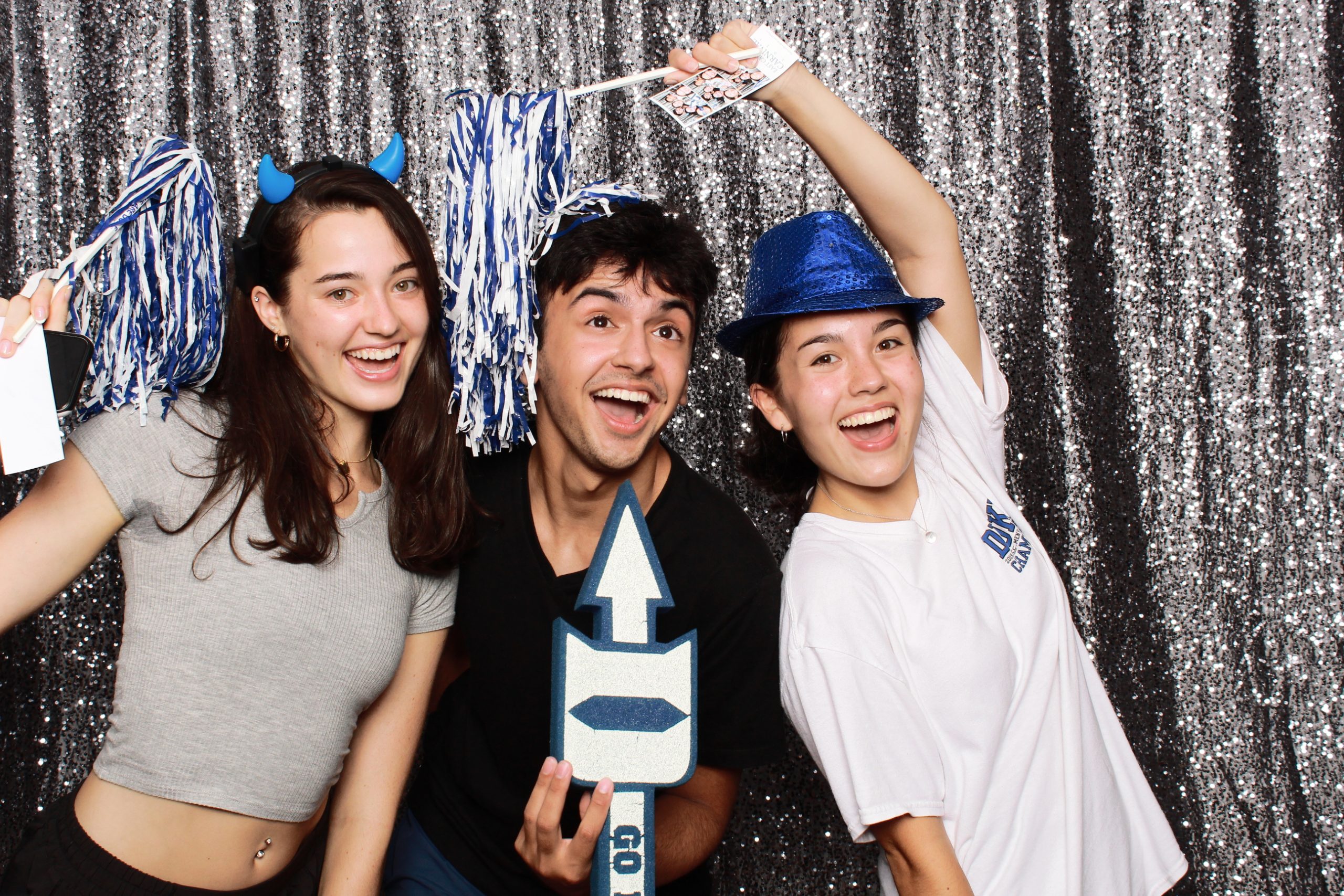 students pose in photo booth with props