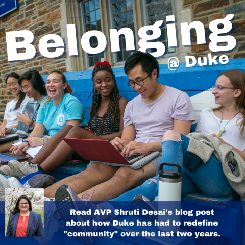 Students sitting on bench laughing on Duke's campus