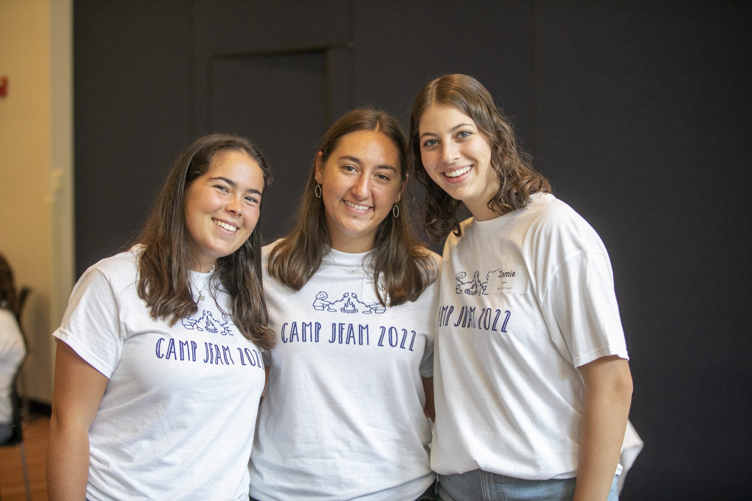 three smiling students in Camp JFAM shirts