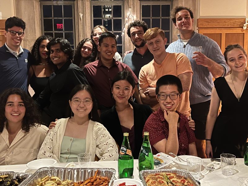 group of students gathered at a table of food