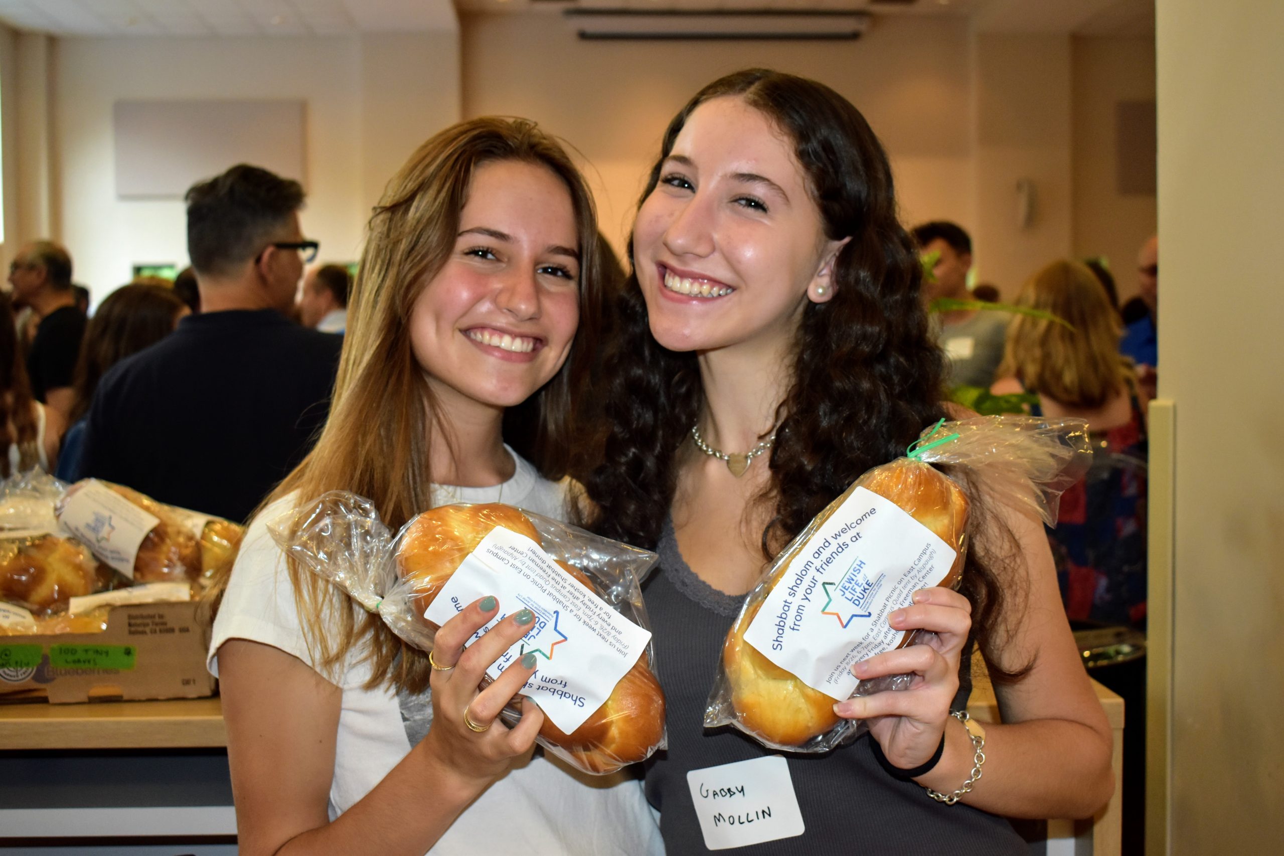 Students smile holding challah