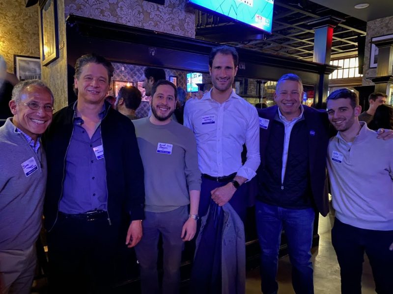 group of alumni pose at a happy hour location