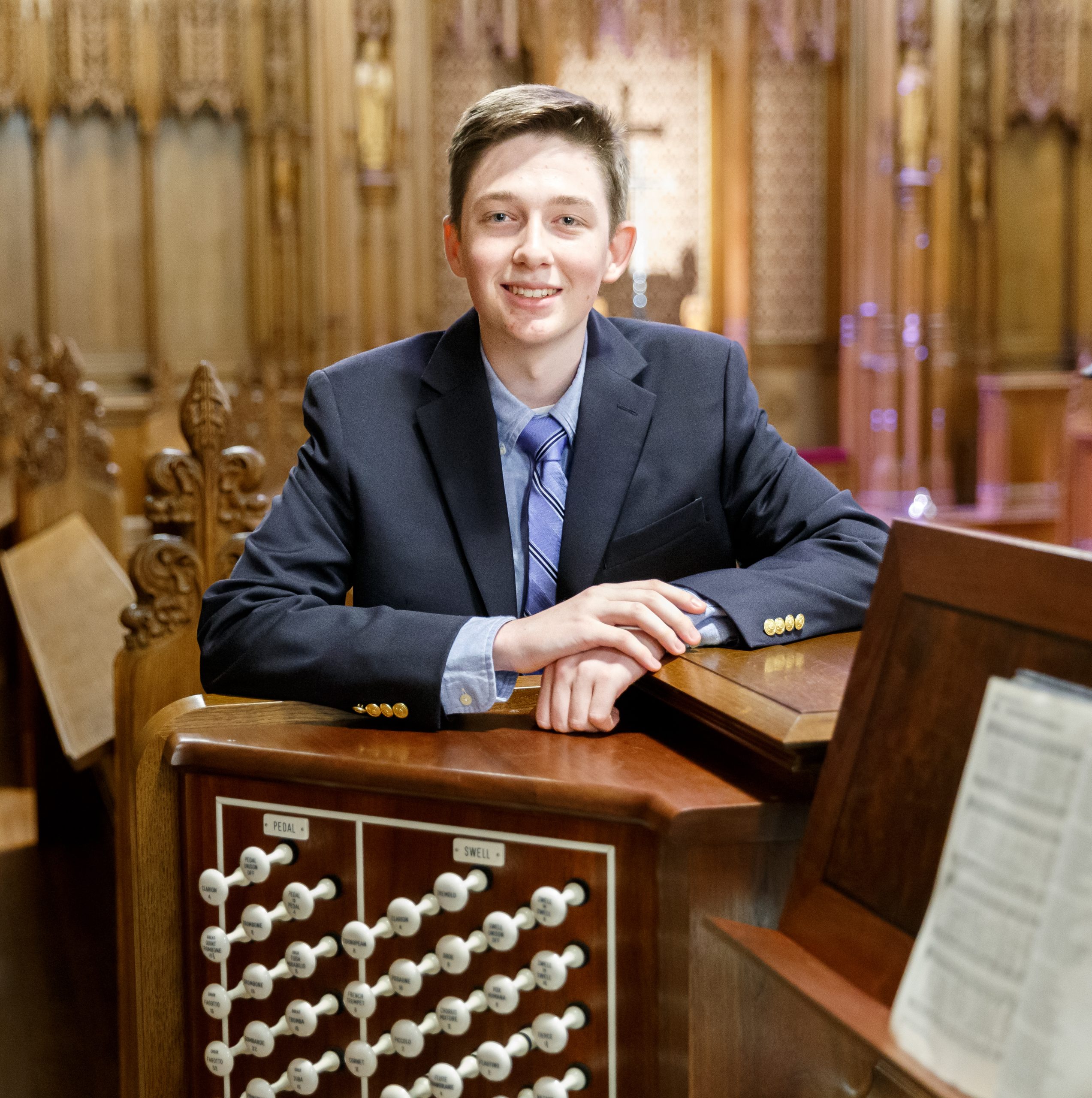 Duke student Bradley Bowen stands next to an organ in the Duke Chapel